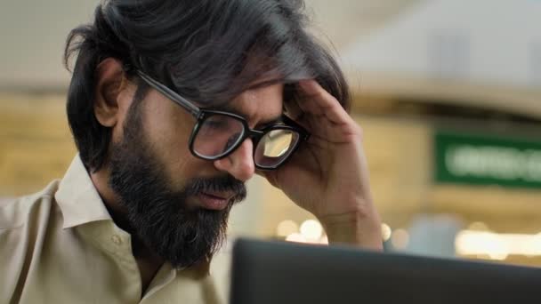 インドのひげは ラップトップのアラビアのビジネスマンとオフィスで働くメガネの男性は 慢性的な重度の頭痛思考トラブルソリューションに苦しむビジネス問題の頭痛に悲しんでいることを強調しました — ストック動画