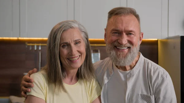 stock image Retired Caucasian happy smiling married couple family gray haired grandma and grandpa wife and husband portrait middle-aged senior mature old man and woman in love hugging in kitchen health insurance