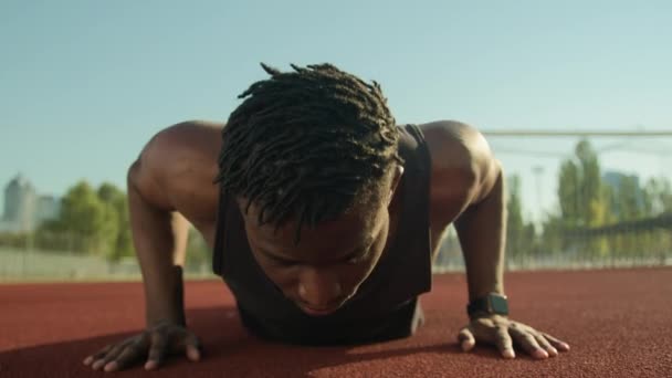 非裔美国男子运动员肌肉强壮健美健美运动员做俯卧撑运动抽水二头肌疲惫的男性运动员在室外锻炼后筋疲力尽的体育场运动健美动机 — 图库视频影像