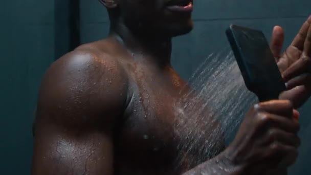 性感的非洲裔美国男人在浴室里洗澡唱歌洗干净的身体下热水早上卫生赤身裸体幽默的家伙在现代黑暗的浴室里洗澡开心的唱歌 — 图库视频影像