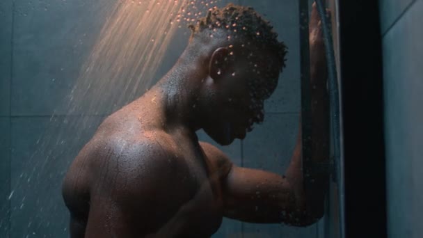 非裔美国人赤身裸体肌肉男在黑暗的浴室里洗澡在落水下洗澡雨滴湿淋淋疲倦的家伙运动后洗澡提神的身体每天清洁男性洗澡 — 图库视频影像