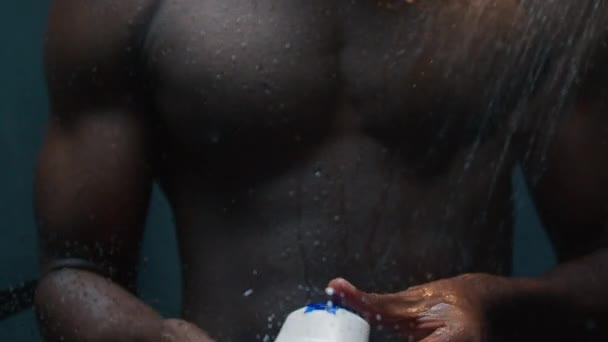 非裔美国人性感裸男用洗发水洗发水用洗发水瓶在深色淋浴浴室运动裸男用洗涤剂肌肉体液肥皂泡沫热水男用美容浴化妆品 — 图库视频影像