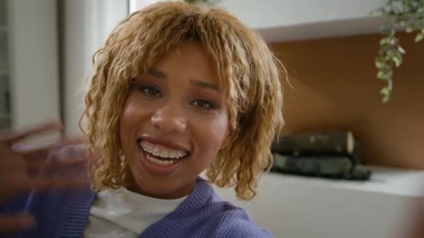 ウェブカムビュービデオコールカンファレンス ブログ 歯のブレースで微笑みます 幸せなアフリカ系アメリカ人女性 インフルエンサー ブロガー ソーシャルメディアのためのセルフィー携帯電話の記録ビデオを作る — ストック動画