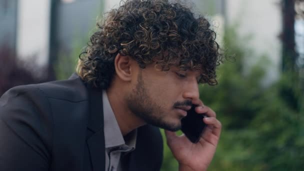 Upset氏は 都市でムスリムインドのビジネスマンが携帯電話を話すことは失敗に苦しむ 悪いニュースが失われたプロジェクトの困難を却下するヒスパニックビジネスマンアラビアの男のスマートフォン会話 — ストック動画