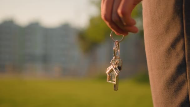 クロップビュー女性の手 アフリカ系アメリカ人女性の少女リアルタイヤ買い手 新しい家に鍵の束を保持しています シティパークで自分の家所有の不動産 ぼやけた高層ビルの芝生の背景 — ストック動画