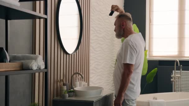 白胡子老年男子成熟的中年男子退休男子在浴室用梳子梳理灰白头发时照镜子 — 图库视频影像