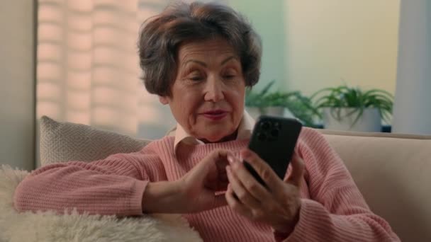 Kaukasiske Gamle Kvinde Chatter Mobiltelefon Sociale Medier Sjove Nyheder Ser – Stock-video