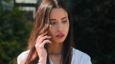 Ciddi şaşkın iş kadını kadın girişimci kız öğrenci sokakta telefonla konuşuyor iş görüşmelerine uzaktan kumandayla iletişim kuruyor dışarıda akıllı telefon kadın portresi üzerinde cep telefonu uygulaması kullanıyor.