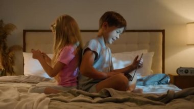 Mutlu Kafkasyalı çocuklar, erkek kardeş kardeş kardeş kardeş kardeş evde bir video oyunu oynuyor dizüstü bilgisayar ve telefon kullanarak genç nesil internet teknolojisi bağımlılığı kavramını kullanarak.