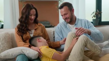 Kafkasyalı mutlu bir aile babası, küçük tatlı bir oğlu olan bir anne, eğleniyor. Kanepede birlikte rahatlıyor. Kaygısız bir ebeveyn, çocuk gülüyor, evde sarılıp yatıyor.