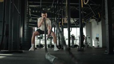 Azimli Kafkas sporcusu aktif sporcu vücut geliştirme antrenmanı spor kaslı adam erkeklik antrenmanı dövüş halatları spor ekipmanları fitness kulübü fiziksel egzersiz ağırlık kaldırma çabası