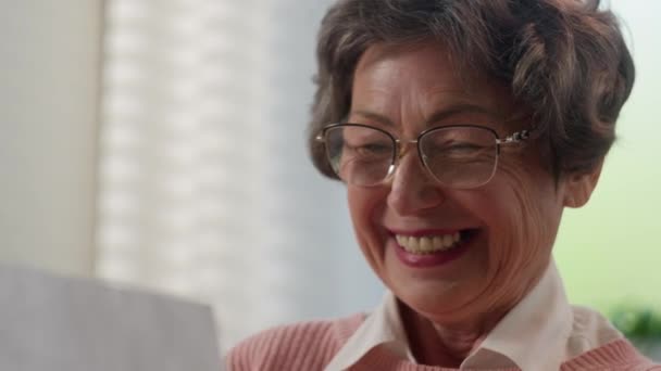 快乐地笑着快乐地笑着白种人老妇人读好消息女退休老太太老奶奶读纸质信件收到家里人送来的生日贺卡 — 图库视频影像