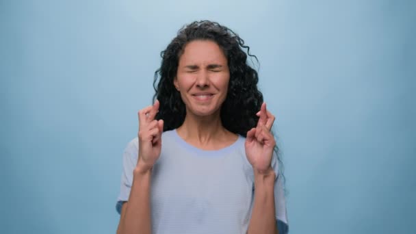 青い背景の肖像画 コピースペースを広告 アラビアの女性希望のインドの女性 ラテン系女性 ヒスパニックの女性 希望は指を横切って祈る 神に期待ジェスチャーの願望を祈る — ストック動画