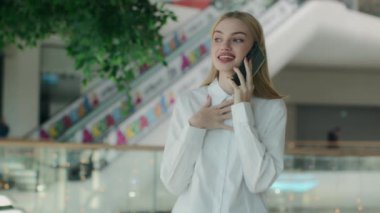 Neşeli iş kızı genç iş kadını akıllı telefon konuşması alışveriş merkezinde arkadaşça sohbet eden kapalı alanda gülümseyen beyaz kadın hoş sohbetler.