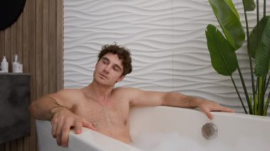 Beyaz sakin sakin sakin adam sıcak sıcak küvette dinleniyor banyo temizliği yapıyor sıcak küvette dinleniyor köpüklü erkek adam duşta dinleniyor otel lüksünde rahat