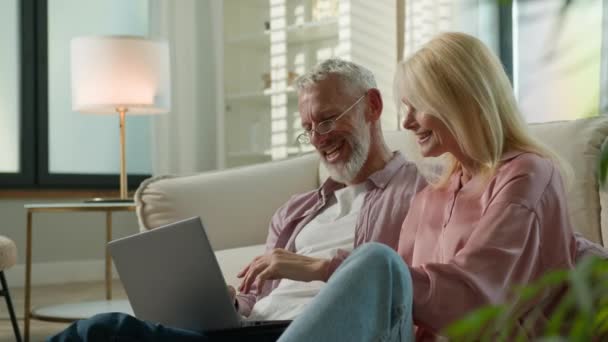 幸せな成功した高齢者結婚カップル 白人男性 リモートショッピング オンラインストアで一緒にリモートショッピング インターネットでノートパソコンの本のチケットを使用して ソーシャルネットワークのトーク 購入を議論 — ストック動画