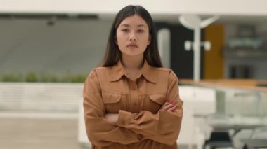 Kendine güvenen Asyalı güçlü iş kadını girişimci kadın lider Çinli Japon kadın kafe çalışanı iş kadını ofis işyerinde el ele tutuşan feminizme bakıyor.