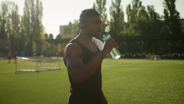 Уставший Афроамериканец Атлетический Спортсмен Потный Бегун Ходьба Открытый Стадион Слушать — стоковое видео