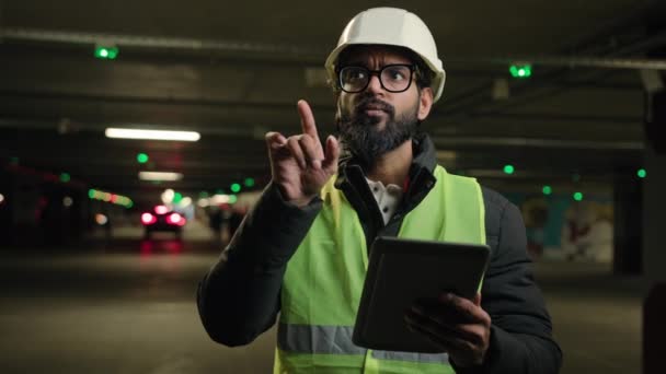 工头巡查停车场地下城市工业重工业工程师阿拉伯男子印度建筑工人硬帽设计师制造工人数码平板电脑交谈视频会议 — 图库视频影像