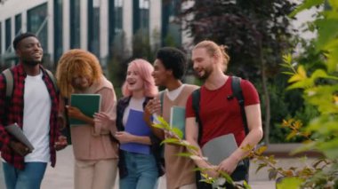 Üniversite arkadaşlığı komik duygusal neşe dolu çeşitli insanlar lise öğrencileri mutlu çok ırklı sınıf arkadaşları çok ırklı öğrenciler gülerek yürüyen şehir hakkında konuşuyorlar.