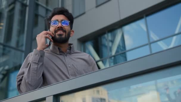 アラビアのインドの男の商業起業家笑う男ビジネスマンは オフィスバルコニーで屋外で電話を話す成功した男性雇用主は ビジネス会話を交渉する — ストック動画