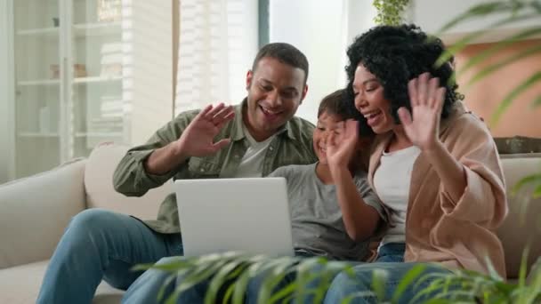 快乐的非洲裔美国人家庭妈妈爸爸和儿子用手提电脑摄像头远程视频呼叫多种族父母小男孩挥手问候亲戚在家里的远程通信设备 — 图库视频影像
