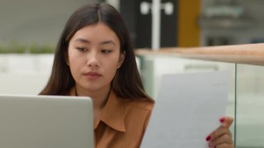 Asyalı iş kızı uzman mali veri analisti ofis yöneticisi kadın iş kadını Japon Koreli Çinli kadın dizüstü bilgisayarla çalışan iş belgeleri fatura analizi