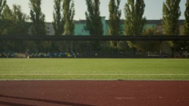 Kırpılmış kaslı erkek bacakları tanınmayan Afrikalı Amerikalı erkek sporcu spor ayakkabılı triatlet açık hava stadyumunda tek başına koşan koşucu spor müsabakası.