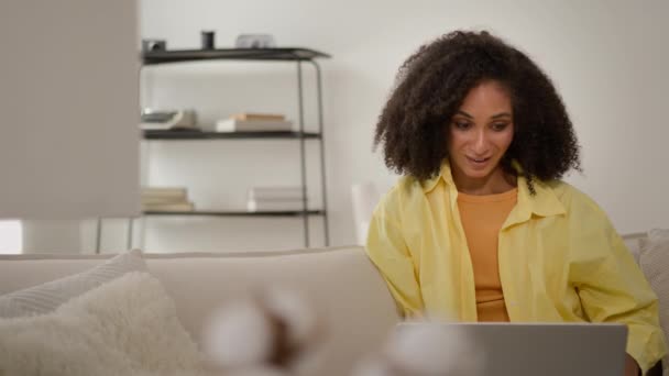 驚くほど幸せな若いアフリカ系アメリカ人女性少女の使用ラップトップコンピュータは 良いニュースを受け取ります 突然の勝利女性のビジネスマンは 宝くじゲームジャックポットの勝利を祝います 自宅でオンラインショッピング — ストック動画