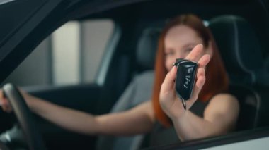 Heyecanlı bayan müşteri alıcısı, yeni araba sahibinin içinde gülümseyen mutlu bir kadın, kameranın anahtarlarını gösteriyor, gülüyor, araba galerisindeki oto-kız satın almaktan keyif alıyor, kiralık araba mağazası taşımacılığı, anahtar taşıyor.
