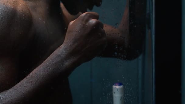 疲惫不堪的非洲裔美国人赤身裸体男子在淋浴中落水愤怒的家伙撞墙锻炼后紧张力不从心焦虑症思考问题危机男性清洗身体的卫生 — 图库视频影像