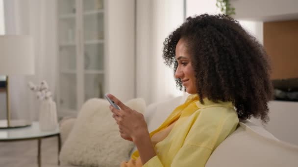 Красивая Афро Американская Женщина Расслабляется Уютном Диване Использовать Мобильный Телефон — стоковое видео