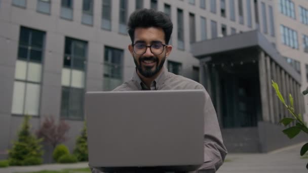 アラビアのインドのビジネスマン イスラム教徒のマネージャー 笑顔の雇用主Ceoの労働者はノートパソコンのデジタルビジネス商取引プロジェクトをタイプする屋外で働く — ストック動画
