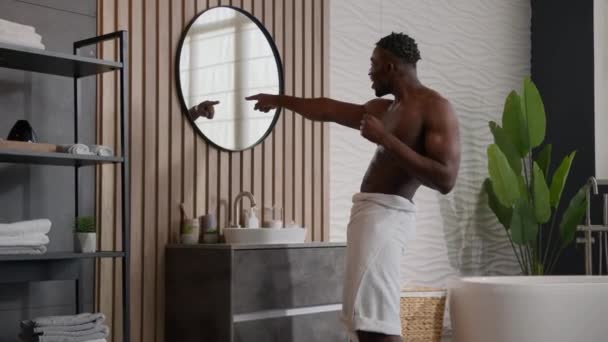 有趣的非洲裔美国男子运动员在镜像的家里唱歌指尖淋浴快乐的族裔肌肉男穿着浴巾臀部欢快的跳舞音乐在浴室里赢得了舞蹈 — 图库视频影像