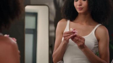 Ayna yansıması çekici Afro-Amerikan kadın dudaklarını krem göz makyajı sabah güzellik rutin etnik kız nemlendirici ruj sürüyor pürüzsüz organik kozmetik