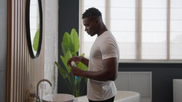 アフリカ系アメリカ人男性 歯科ケア製品の口の衛生で歯をきれいにする バスルームで洗う 抗菌口洗い 新鮮な呼吸 液体の口腔のリフレッシュメント 毎日のルーチン — ストック動画