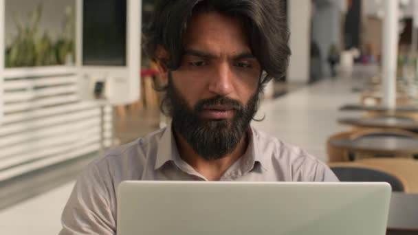 集中した深刻なインド人男性忙しいビジネスマンオフィスワーカーマネージャー従業員は ビデオ通話リモートビジネス交渉を介して話すコンピュータ思考の問題でオンラインで働くラップトップを入力 — ストック動画