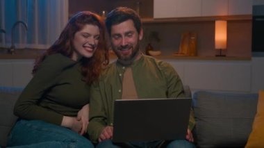Kafkasyalı mutlu bir aile çifti karı koca karı koca sosyal medyada gezinen müşteriler internet üzerinden alışveriş yapanlar evde dizüstü bilgisayar kullanarak ürün siparişi verenler seçiyorlar.
