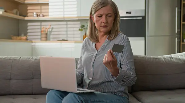 Mature caucasian woman retired senior lady dissatisfied client experiencing problem on laptop with online payment failure bank credit card error mistake unsuccessful transaction trouble wrong password