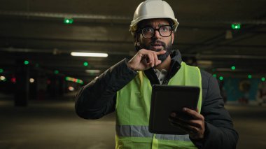 Ağır endüstri teknolojisi mühendisi Arap adam. Hintli mimar. Düşünen mimar. Düşünen kafa yorma problemi çözümü için dijital tablet güvenlik kontrolü kullan.