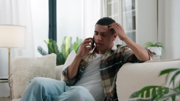 悲しい動揺 イライラしたショック アフリカ系アメリカ人男性 エスニックな人 ストレス 家庭で電話を話す 悪いニュース ショック スマートフォン ネガティブな会話 — ストック動画