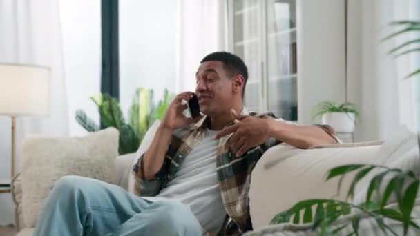 Szczęśliwy Afroamerykanin Domu Kanapa Facet Facet Mężczyzna Beztroski Rozmawianie Smartfon — Wideo stockowe
