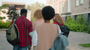 Çeşitli üniversite arkadaşları lise öğrencileri, çok kültürlü sınıf arkadaşları dışarıda yürüyüş yapmak için acele eden Afrikalı Amerikalı öğrenci kameraya gülümsüyor.