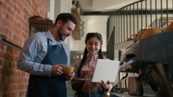 多様なポジティブな男性女性カフェテリア従業員小規模ビジネスオーナーカフェマネージャーウェイターは ワークプランレストランスタッフミーティングについて話す新しい戦略を開発するラップトップで作業スケジュールを議論 — ストック動画