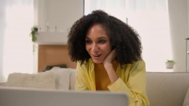 Duygusal olarak heyecanlı, mutlu, Afro-Amerikalı, etnik kız, serbest çalışan iş kadını. Laptop bilgisayarının başında sohbet ediyor. İnternette arkadaşlarıyla sohbet ediyor.