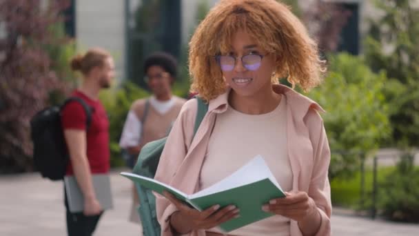 Afričanky Americká Studentka Čtení Knihy Venku Úsměvem Kameru Ukazující Palec — Stock video