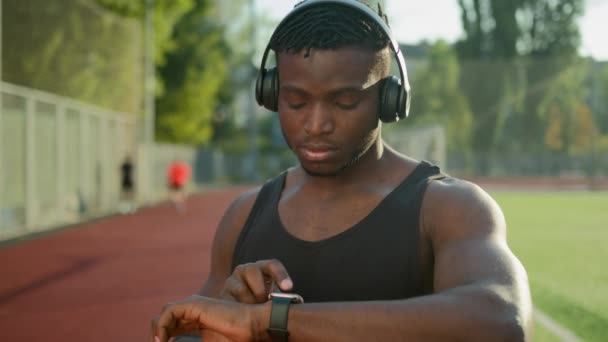 Pensativo Hombre Afroamericano Deportista Atleta Auriculares Uso Smartwatch Ciudad Prepararse — Vídeos de Stock