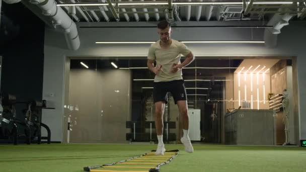 カカシアのスポーツマン サッカー選手 スポーツジムでのトレーニング 梯子スポーツ機器のトレーニング フィットネスクラブのサッカーの試合の男性アスリートのための準備 — ストック動画