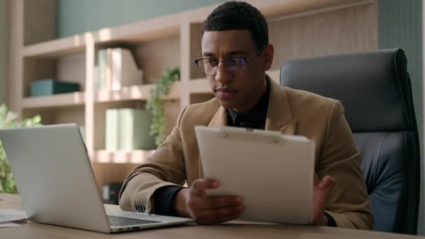 ビジネスマン アフリカ系アメリカ人会計士 男性オフィスワーカー 財務データ分析計画を書く ビジネスマン ラップトップコンピュータの管理 プロジェクトの研究論文 署名文書 — ストック動画