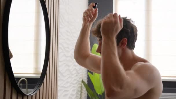 白种人赤身裸体男子镜像反射浴室梳头风格应用发胶保护秃顶疗法喷洒水治疗发式晨光美容常规程序 — 图库视频影像